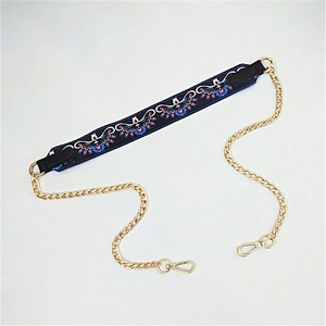 Detail of embroidered ethnic strap with gold metal chain and swivel lobster clasps
