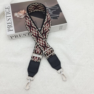 Ethnic style woven cross body strap with red and black geometric patterns and silver hardware