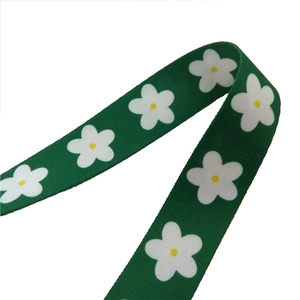 Adjustable green woven bag strap with white daisy pattern for shoulder and crossbody bags