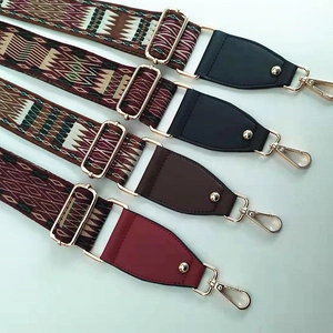 Dettaglio di tracolle larghe ricamate in stile etnico con ganci in metallo dorato