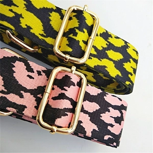 Macro shot of high-density leopard print woven straps with polished gold metal buckles