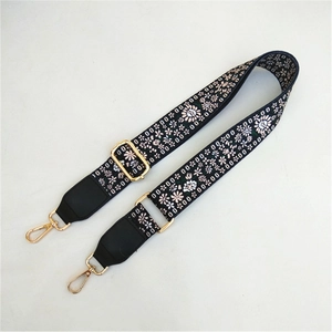 Detailed view of bohemian floral print bag strap with adjustable gold buckle and swivel hooks