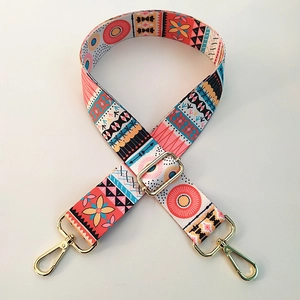 Detailed view of bohemian style embroidered bag strap with golden metal swivel hooks