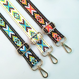 Close-up of bohemian geometric woven bag straps with gold metal hooks and hardware
