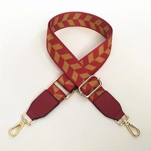 Adjustable woven shoulder strap for bags with red and yellow arrow patterns and gold clips
