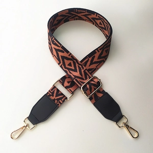 Detail of adjustable geometric strap with orange bohemian pattern and gold lobster clasp