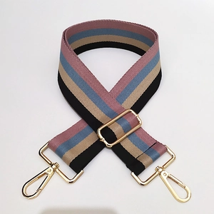 Detail of adjustable woven purse strap with colorful stripes and gold metal buckles