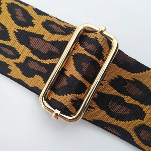 Detail of adjustable leopard print bag strap featuring high-density weave and gold buckle