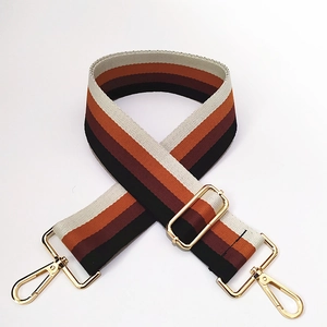 Detail of adjustable cotton stripe bag strap with vintage pattern and gold metal hooks
