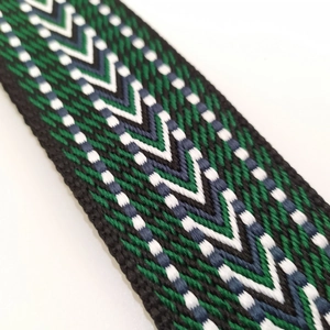 Macro view of woven chevron pattern strap in green, black, and white embroidery
