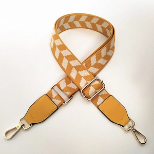 Detail of adjustable wide nylon shoulder strap with yellow geometric arrow patterns