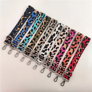 Macro shot showing diverse leopard print nylon bag straps with silver metal adjustment buckles