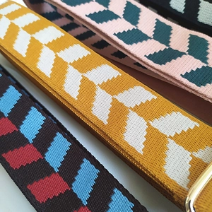 Detail of colorful jacquard wide straps with gold metal buckles and chevron patterns