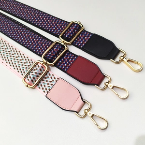 Détail de trois bandoulières réglables en jacquard avec mousquetons en métal doré