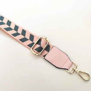 Detail of adjustable pink and gray chevron woven strap with gold metal hooks