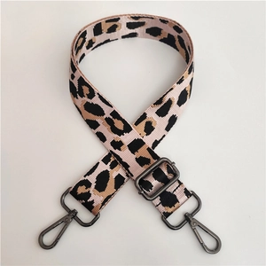 Detail of adjustable leopard print nylon shoulder strap with dark gray metal hooks