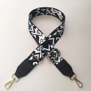 Adjustable geometric woven bag strap with green white patterns and gold metal buckles
