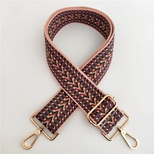 Close-up of colorful geometric embroidered bag strap with gold metal lobster clasps
