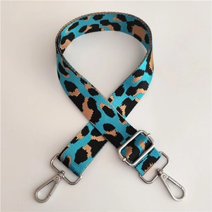 Close-up of leopard print nylon bag strap with silver metal lobster clasps and buckles