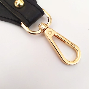 Adjustable wide shoulder strap with golden metal clasp and black leather details