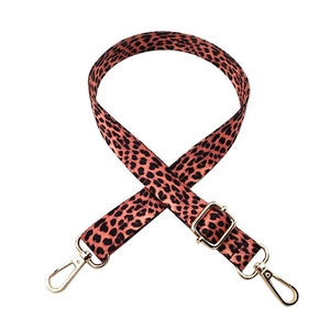 Close-up of leopard print bag strap with adjustable golden metal hooks on white background