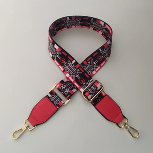 Detail of adjustable woven bag strap with geometric patterns and golden metal hardware