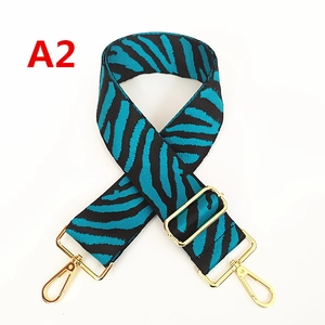 Détail de la bandoulière zébrée avec crochets dorés et boucle réglable en métal