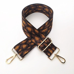 Detail of adjustable leopard print bag strap with polished light gold metal hardware