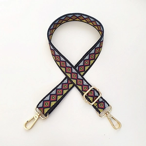 Close-up of geometric ethnic pattern woven strap with gold metal buckles for bags