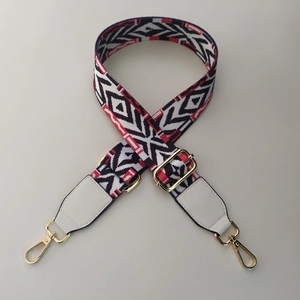 Close-up of ethnic woven bag strap with geometric patterns and golden metal clasps