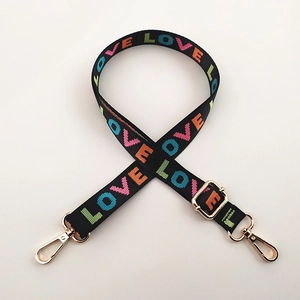 Detail of black woven shoulder strap with colorful LOVE text and gold metal buckles