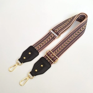Detail of colorful geometric woven bag strap with golden hardware and leather ends