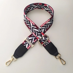 Close-up of ethnic geometric pattern woven strap with gold metal buckles and leather ends