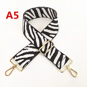 Détail de la bandoulière large ajustable en toile motif zèbre avec boucles dorées
