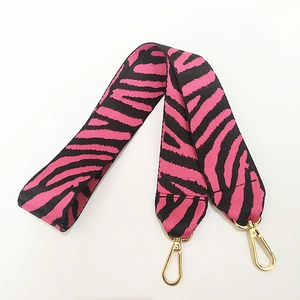 Dettaglio della tracolla in nylon zebrato rosa e nero con moschettoni in metallo dorato