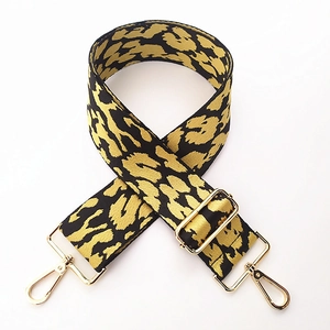 Detail of adjustable leopard print bag strap featuring heavy-duty gold metal lobster clasps