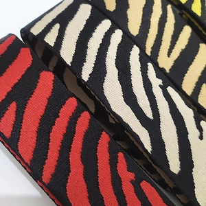 Dettaglio macro di tracolle per borse in nylon con motivo zebrato in vari colori