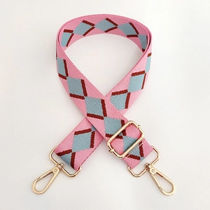 Detail of pink and blue argyle woven canvas bag strap with golden lobster clasps