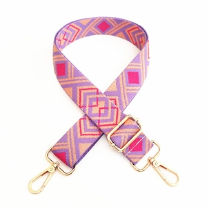 Close-up of ethnic jacquard canvas strap with geometric patterns and gold metal buckles