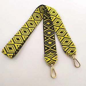 Detail of yellow and black geometric woven canvas strap with gold metal hooks