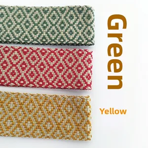 Détail des bandoulières de sac en jacquard tissé aux motifs géométriques vert, rouge et jaune