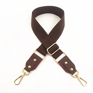 Detail of adjustable dark brown wide cotton shoulder strap with gold metal lobster hooks