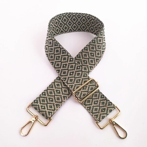 Détail de la bandoulière large brodée avec motifs géométriques verts et beiges