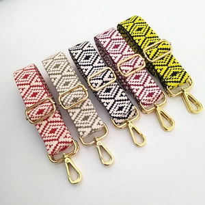 Détail de cinq bandoulières tissées aux motifs géométriques avec des boucles en métal doré