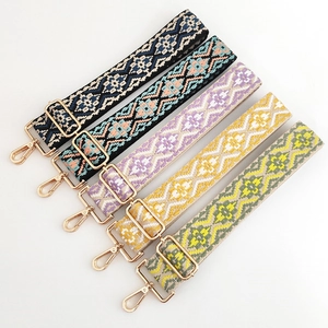 Dettaglio di tracolle regolabili in stile etnico con motivi jacquard e ganci dorati