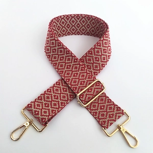Détail de la bandoulière réglable en coton avec motifs géométriques rouge et blanc
