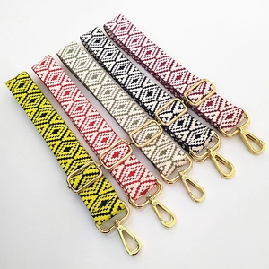 Détail de cinq bandoulières de sac brodées de style ethnique avec crochets dorés