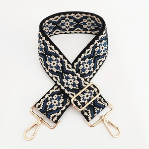 Dettaglio della tracolla in jacquard geometrico con ganci in metallo dorato e fibbia regolabile