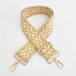 Dettaglio della tracolla in jacquard intrecciato geometrico con ganci dorati