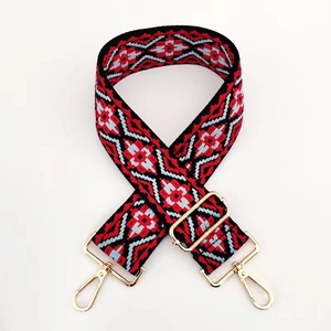 Dettaglio tracolla jacquard geometrica con ganci in metallo dorato su sfondo bianco